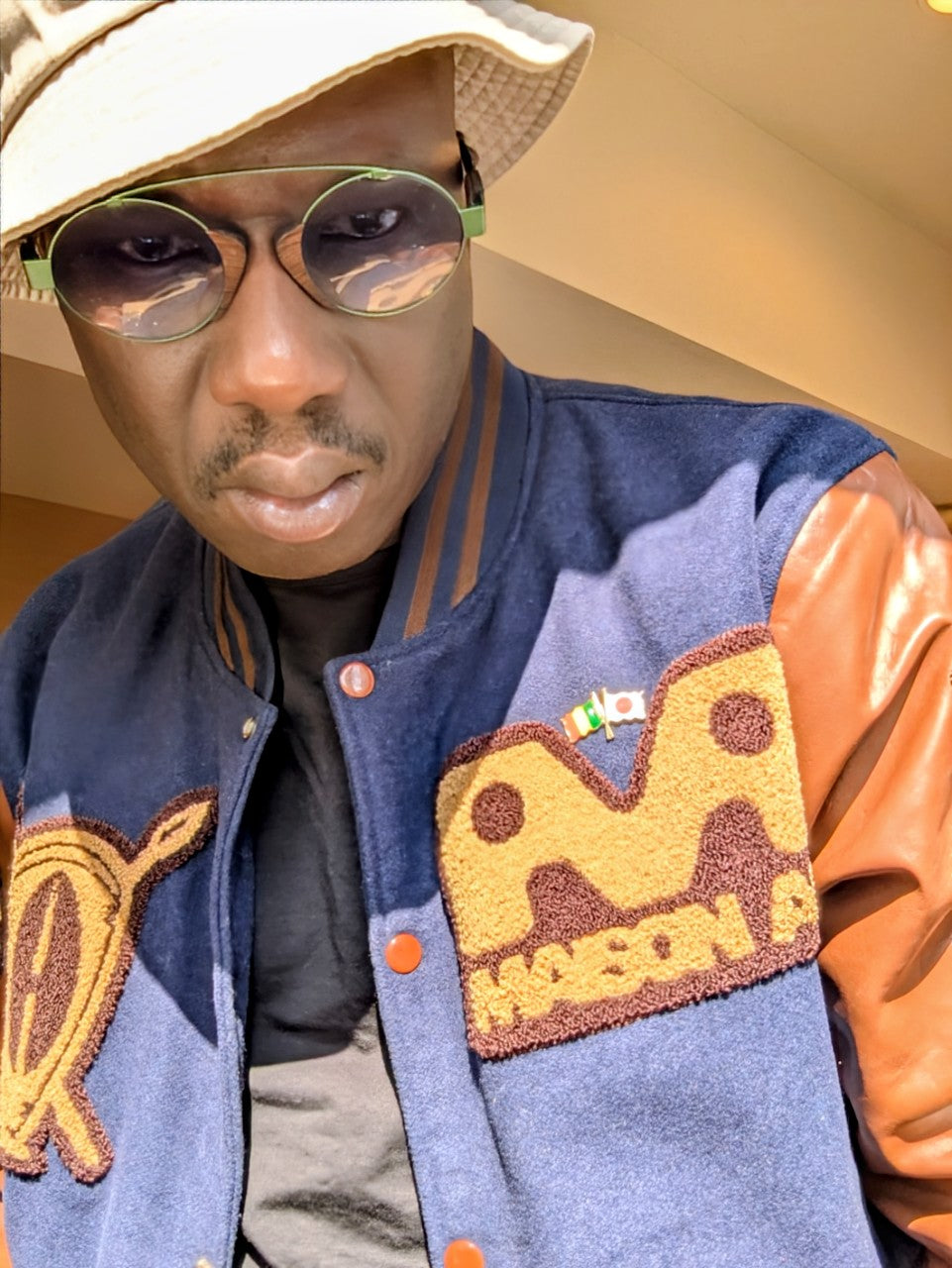 Le Teddy de l'Unité : Plus qu'une veste, c'est le symbole de notre famille. Le Teddy "Univers AA" est la seule pièce qui réunit les trois emblèmes de la marque : African Armure, Maison AA et Young Nation by AA.